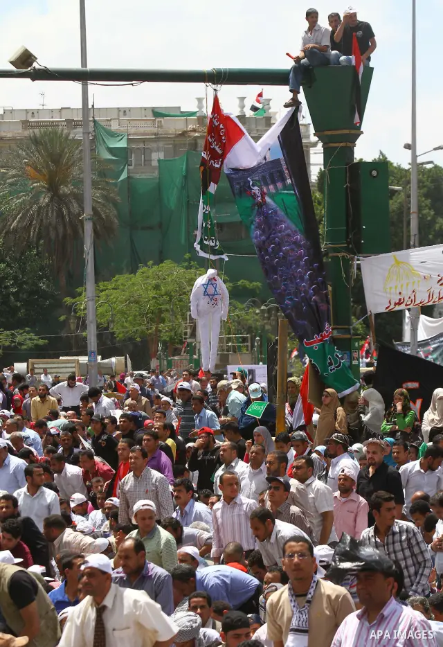 Egyptian demonstrators wave Palestinian flags and Egyptian flags during a rally at Cairo's Tahrir Square on May 13, 2011 during a protest calling for national unity after attacks on Egyptian churches, and solidarity with...