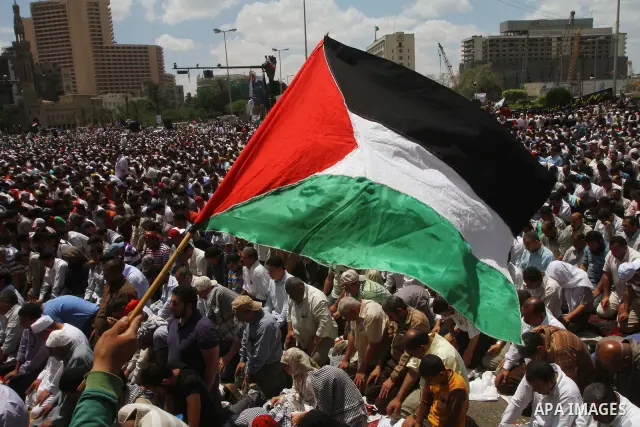 Egyptian demonstrators wave Palestinian flags and Egyptian flags during a rally at Cairo's Tahrir Square on May 13, 2011 during a protest calling for national unity after attacks on Egyptian churches, and solidarity with...