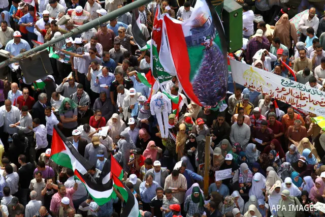 Egyptian demonstrators wave Palestinian flags and Egyptian flags during a rally at Cairo's Tahrir Square on May 13, 2011 during a protest calling for national unity after attacks on Egyptian churches, and solidarity with...