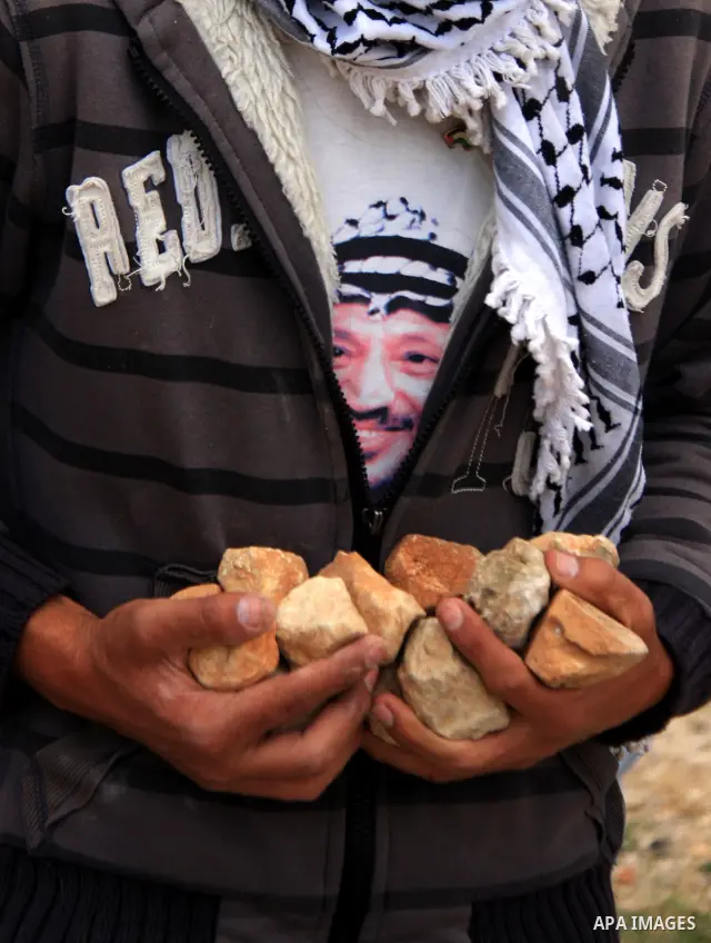 A Palestinian youth holds stones to be thrown at Israeli forces during a protest against Israel's controversial separation barrier and to mark the 63th anniversary of "Nakba" (catastrophe) on May 13, 2011in the West Bank...
