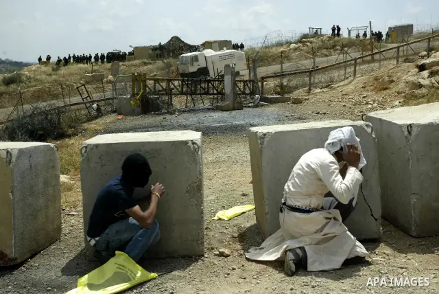 Palestinian protestors take cover from colored water fired by Israeli soldiers during a protest against Israel's controversial separation barrier and to mark the 63th anniversary of "Nakba" (catastrophe) on May 13, 2011i...