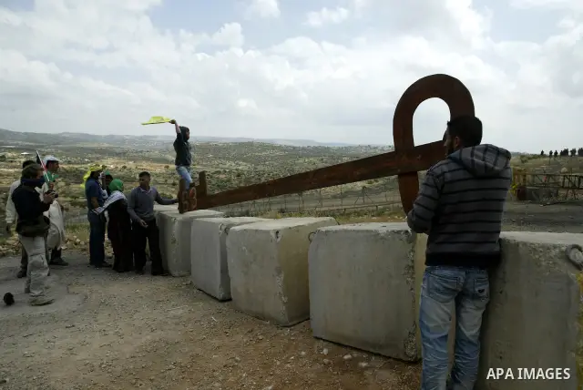 Palestinian protestors carry a big makeshift key during a protest against Israel's controversial separation barrier and to mark the 63th anniversary of "Nakba" (catastrophe) on May 13, 2011in the West Bank village of Bil...