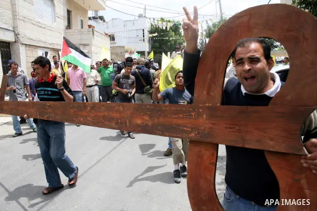 Palestinian protestors carry a big makeshift key during a protest against Israel's controversial separation barrier and to mark the 63th anniversary of "Nakba" (catastrophe) on May 13, 2011in the West Bank village of Bil...