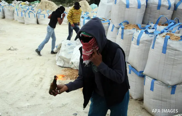 Palestinian youths hurl stones towards Israeli border policemen (not seen) in the East Jerusalem neighborhood of Silwan, on 13 May 2011. Riots broke out in several flashpoints in East Jerusalem following the Friday Praye...