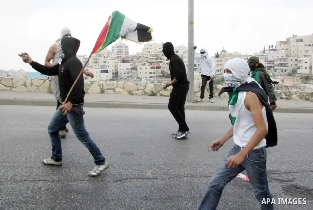 Palestinian youths hurl stones towards Israeli border policemen (not seen) in the East Jerusalem neighborhood of Silwan, on 13 May 2011. Riots broke out in several flashpoints in East Jerusalem following the Friday Praye...