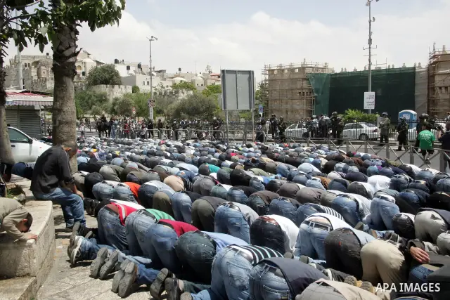 Palestinian Muslim worshipers perform Friday prayer outside Jerusalem's Old City on May 13, 2011 as Israeli police flooded the streets of Jerusalem, fearing violence as Palestinians began marking the "Nakba" or "catastro...