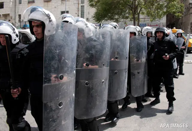 Palestinian security forces block the way of Hamas demonstrators who were trying to reach an Israeli-controlled checkpoint in the West Bank city of Hebron following a rally to mark the 63th anniversary of "Nakba" (catast...