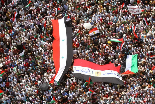 Egyptian demonstrators wave Palestinian flags and Egyptian flags during a rally at Cairo's Tahrir Square on May 13, 2011 during a protest calling for national unity after attacks on Egyptian churches, and solidarity with...