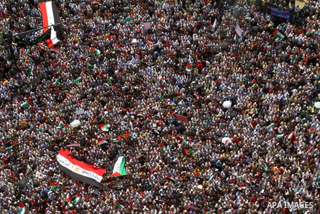 Egyptian demonstrators wave Palestinian flags and Egyptian flags during a rally at Cairo's Tahrir Square on May 13, 2011 during a protest calling for national unity after attacks on Egyptian churches, and solidarity with...