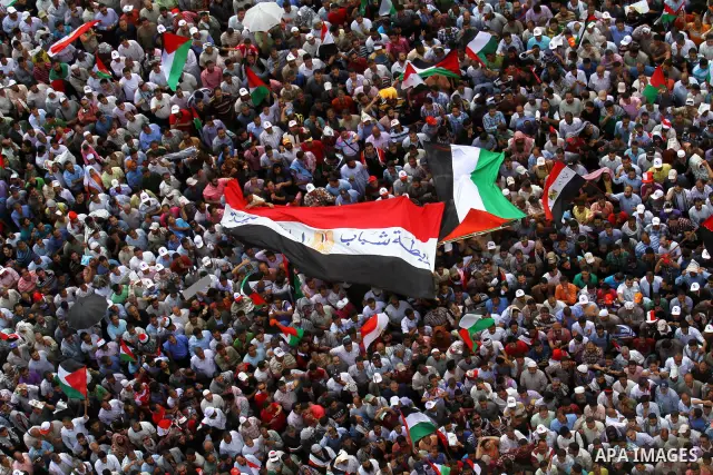 Egyptian demonstrators wave Palestinian flags and Egyptian flags during a rally at Cairo's Tahrir Square on May 13, 2011 during a protest calling for national unity after attacks on Egyptian churches, and solidarity with...