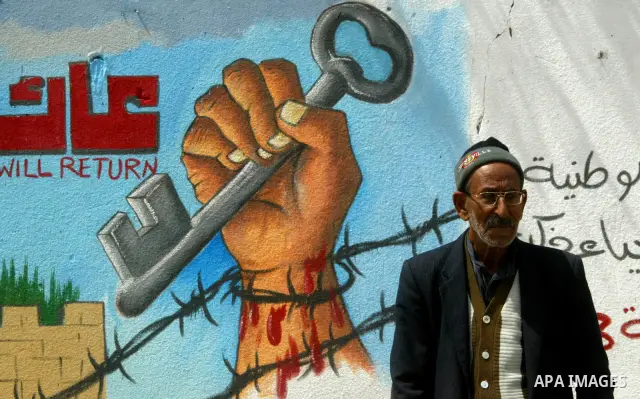 A Palestinian man poses in front of a mural painting on the theme of return of refugees to their land in what is now Israel on May 14, 2011 in the southern Gaza Strip refugee camp of Rafah, where Palestinians are marking...