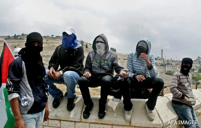 Palestinian youths prepare to hurl stones during clashes following the funeral of a teenager who died after being shot as Palestinians launched events to mourn the 1948 creation of the Jewish state in Jerusalem the day b...