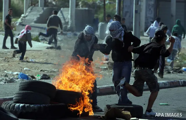 Palestinian youth hurl stones during clashes with Israeli soldiers at the Israeli manned Qalandia checkpoint between Jerusalem and the West Bank city if Ramallah on May 14, 2011, as Palestinians gather in the runup to to...