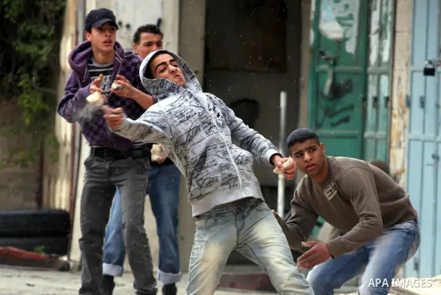 Palestinian youth hurl stones during clashes with Israeli soldiers at the Israeli manned Qalandia checkpoint between Jerusalem and the West Bank city if Ramallah on May 14, 2011, as Palestinians gather in the runup to to...