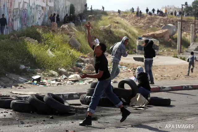 Palestinian youth hurl stones during clashes with Israeli soldiers at the Israeli manned Qalandia checkpoint between Jerusalem and the West Bank city if Ramallah on May 14, 2011, as Palestinians gather in the runup to to...