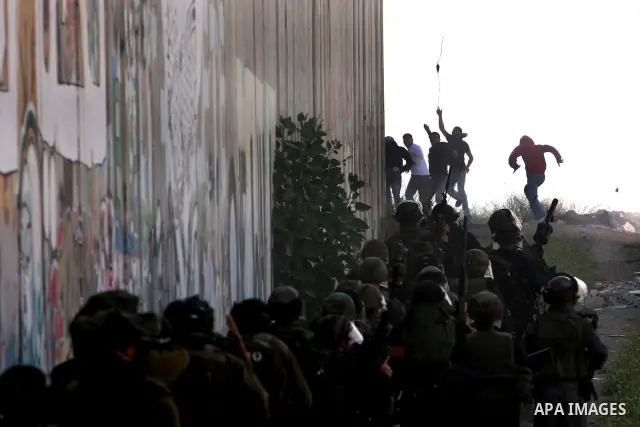 Palestinian youth hurl stones during clashes with Israeli soldiers at the Israeli manned Qalandia checkpoint between Jerusalem and the West Bank city if Ramallah on May 14, 2011, as Palestinians gather in the runup to to...