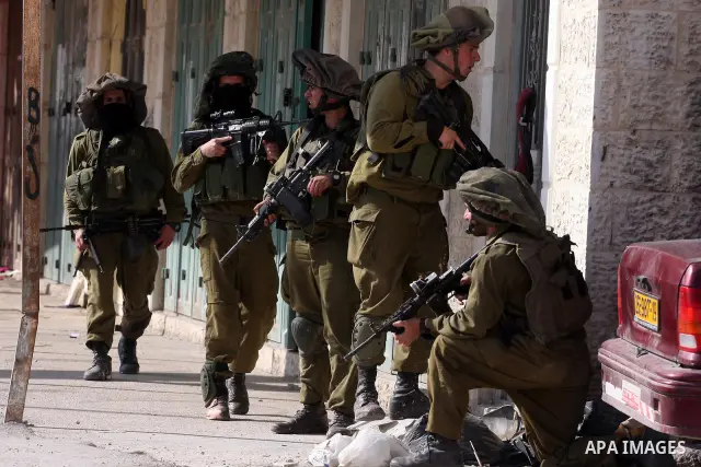 Israeli soldiers run past burning tires during clashes with Palestinian stone throwers at the Israeli manned Qalandia checkpoint between Jerusalem and the West Bank city if Ramallah on May 14, 2011, as Palestinians gathe...