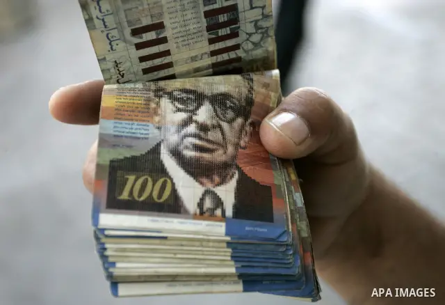 A Palestinian man displays the Israeli shekels at a black markets in the southern Gaza Strip town of Rafah on May 14, 2011. Photo by Abed Rahim Khatib