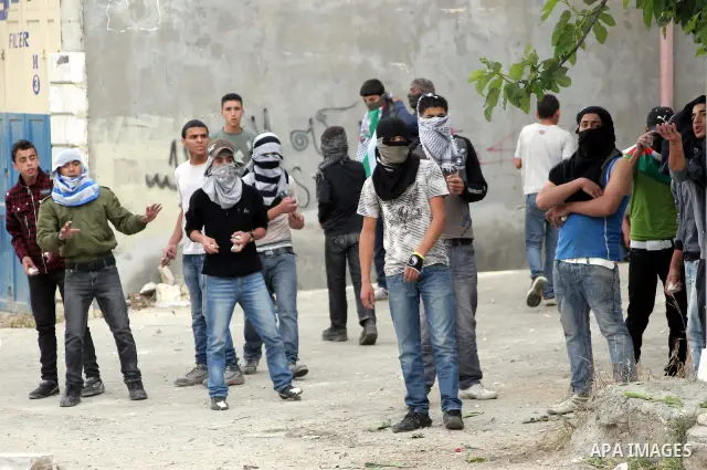 Palestinian youths throw stones at Israeli soldiers during confrontations in the West Bank city of Hebron, while Palestinians mourned on May 15, 2011 the "nakbah" anniversary of Israel's creation in 1948, as a result of...