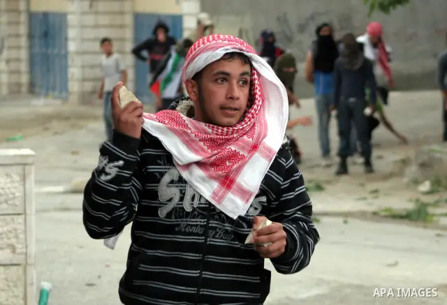 Palestinian youths throw stones at Israeli soldiers during confrontations in the West Bank city of Hebron, while Palestinians mourned on May 15, 2011 the "nakbah" anniversary of Israel's creation in 1948, as a result of...