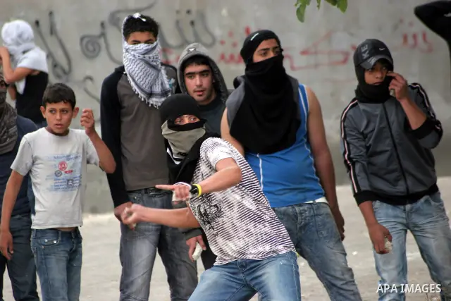Palestinian youths throw stones at Israeli soldiers during confrontations in the West Bank city of Hebron, while Palestinians mourned on May 15, 2011 the "nakbah" anniversary of Israel's creation in 1948, as a result of...