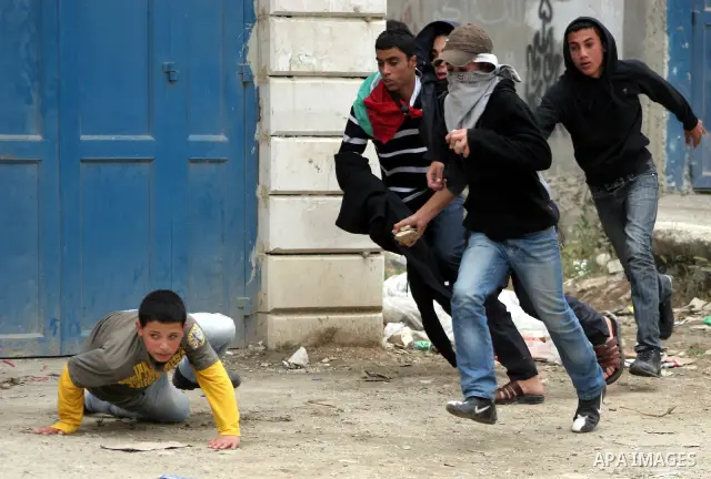 Palestinian youths throw stones at Israeli soldiers during confrontations in the West Bank city of Hebron, while Palestinians mourned on May 15, 2011 the "nakbah" anniversary of Israel's creation in 1948, as a result of...