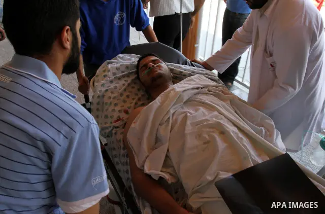 A Palestinian freelance photographer Mohammed Othman arrives to the hospital after he wounded when Israeli troops opened fire during on a massive march heading towards the Erez border crossing in the northern Gaza Strip,...