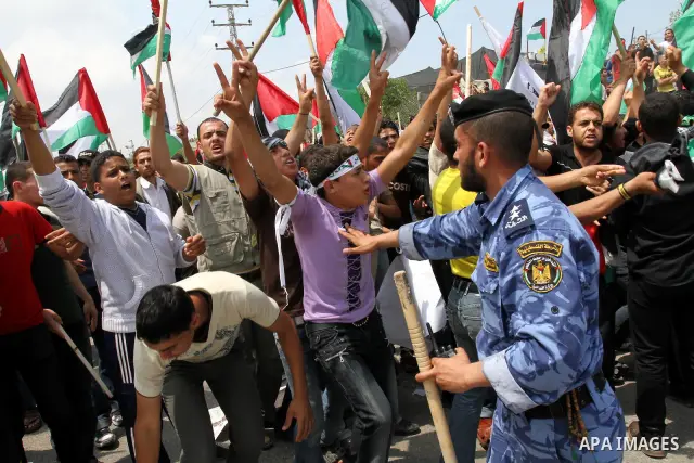 Palestinian protesters wave Palestinian national flags during a demonstration in front of the Erez border crossing in the northern Gaza Strip, on May 15, 2011, as people gathered to mark the "nakbah" or "catastrophe" ann...