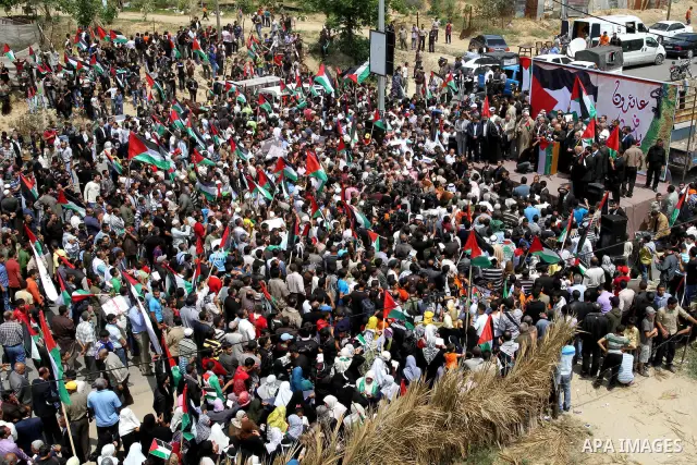 Palestinian protesters wave Palestinian national flags during a demonstration in front of the Erez border crossing in the northern Gaza Strip, on May 15, 2011, as people gathered to mark the "nakbah" or "catastrophe" ann...