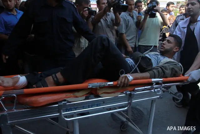 Palestinians wheel a wounded protester after Israeli troops opened fire during a massive march heading towards the Erez border crossing in the northern Gaza Strip, on May 15, 2011, as people gathered to mark the "nakbah"...
