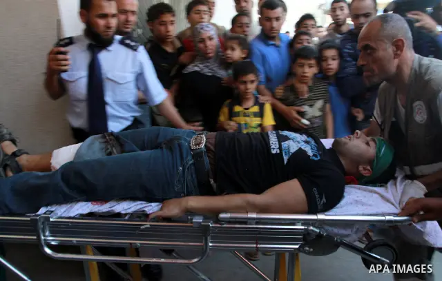 Palestinians wheel a wounded protester after Israeli troops opened fire during a massive march heading towards the Erez border crossing in the northern Gaza Strip, on May 15, 2011, as people gathered to mark the "nakbah"...
