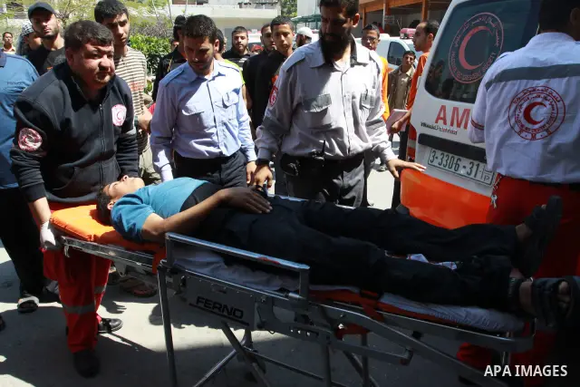 Palestinians wheel a wounded protester after Israeli troops opened fire during a massive march heading towards the Erez border crossing in the northern Gaza Strip, on May 15, 2011, as people gathered to mark the "nakbah"...