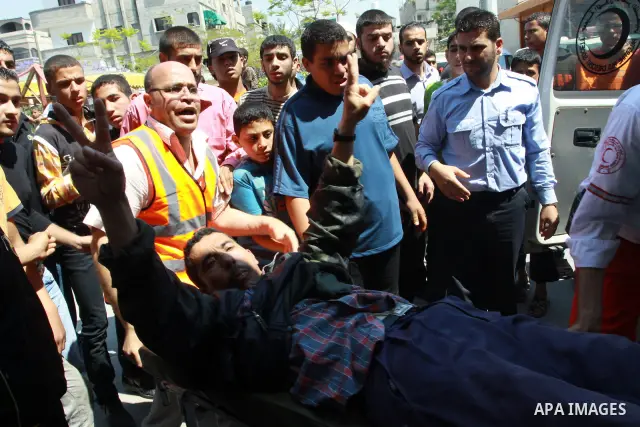 Palestinians wheel a wounded protester after Israeli troops opened fire during a massive march heading towards the Erez border crossing in the northern Gaza Strip, on May 15, 2011, as people gathered to mark the "nakbah"...