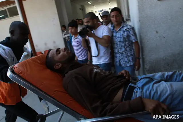 Palestinians wheel a wounded protester after Israeli troops opened fire during a massive march heading towards the Erez border crossing in the northern Gaza Strip, on May 15, 2011, as people gathered to mark the "nakbah"...