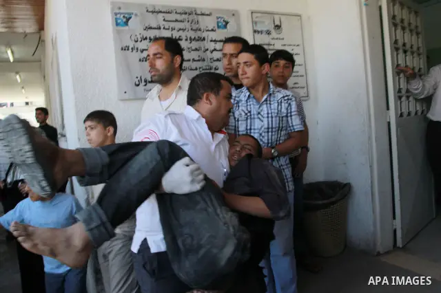 Palestinians wheel a wounded protester after Israeli troops opened fire during a massive march heading towards the Erez border crossing in the northern Gaza Strip, on May 15, 2011, as people gathered to mark the "nakbah"...