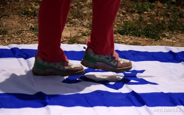 A Palestinian child steps on an Israeli flag during a rally to mark the day of "nakba" or the catastrophe on May 15, 2011 in the Israeli occupied West Bank city of Nablus. Across the West Bank and Palestinian territories...