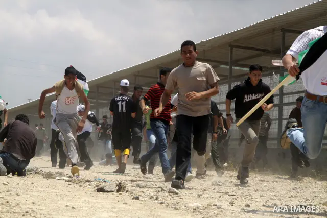 Palestinian protesters run for cover after Israeli soldiers opened fire during a massive march towards the Erez border crossing in the northern Gaza Strip on May 15, 2011 to mark the "Nakba" or "Catastrophe" anniversary...