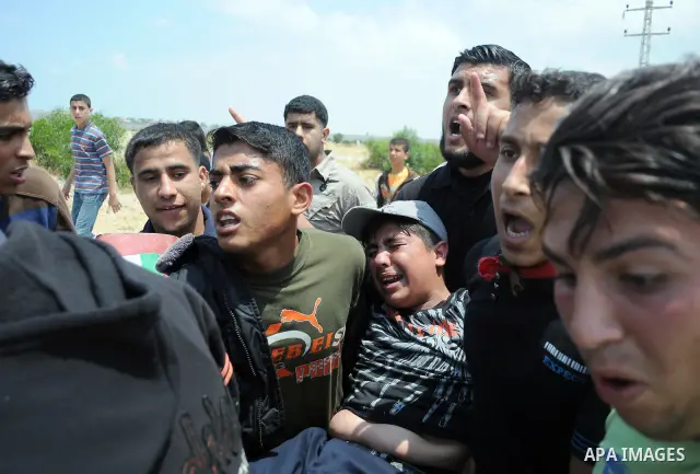 Palestinians carry a wounded protester after Israeli troops opened fire during a massive march heading towards the Erez border crossing in the northern Gaza Strip, on May 15, 2011, as people gathered to mark the "nakbah"...
