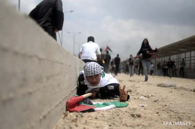 Palestinian protesters run for cover after Israeli soldiers opened fire during a massive march towards the Erez border crossing in the northern Gaza Strip on May 15, 2011 to mark the "Nakba" or "Catastrophe" anniversary...