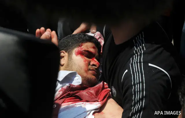 Palestinian youths carry freelance photographer Mohammed Othman after he wounded when Israeli troops opened fire during on a massive march heading towards the Erez border crossing in the northern Gaza Strip, on May 15, 2...