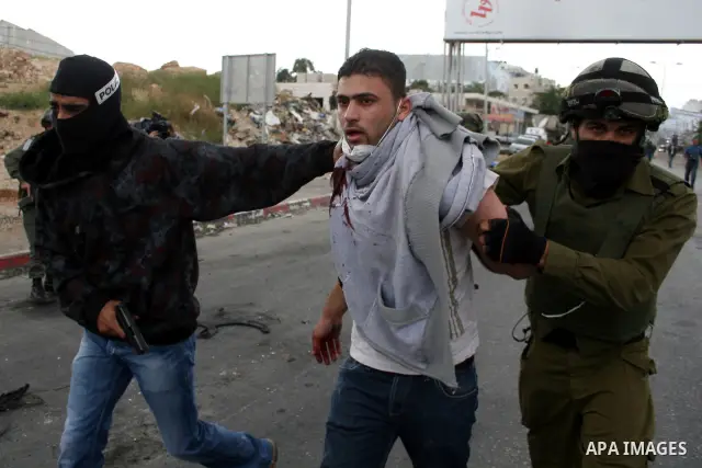 An Israeli soldier and undercover police arrest a Palestinian man during clashes with stone throwers at the Israeli manned Qalandia checkpoint between Jerusalem and the West Bank city of Ramallah on May 15, 2011. Palesti...