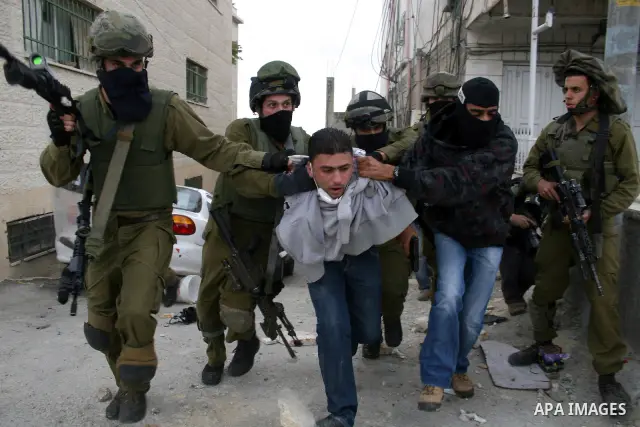 An Israeli soldier and undercover police arrest a Palestinian man during clashes with stone throwers at the Israeli manned Qalandia checkpoint between Jerusalem and the West Bank city of Ramallah on May 15, 2011. Palesti...