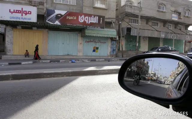 Palestinians walk passed closed shops during a general strike in the southern Gaza Strip town of Rafah on May 16, 2011, to mourn for what israeli occupation done yesterday of shedding the blood of the citizens and Suppre...
