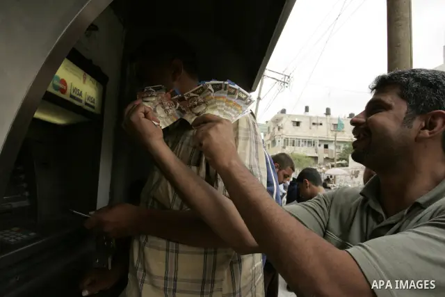 Palestinians employees received their salaries for the month of May through ATMs banks in Rafah in the southern Gaza Strip on May 17, 2011, Where Palestinian Authority delayed to pay salaries for this month after Israel...