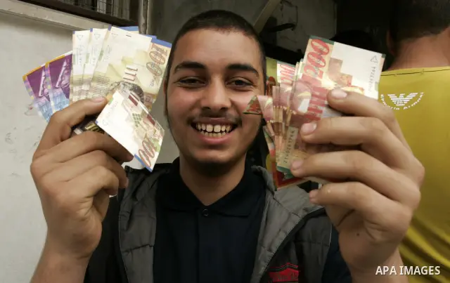 Palestinian employees receive their salaries for the month of May through ATMs banks in Rafah in the southern Gaza Strip on May 17, 2011, Where Palestinian Authority delayed to pay salaries for this month after Israel ba...