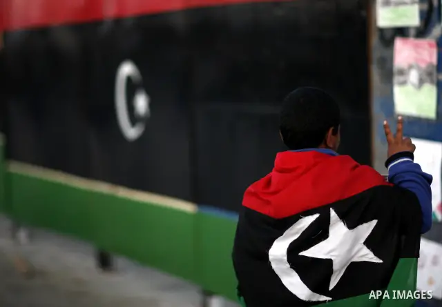 A Libyan youth wears Libya's former flag at a market in the eastern rebel stronghold of Benghazi on May 17, 2011 Photo by Wissam Nassar