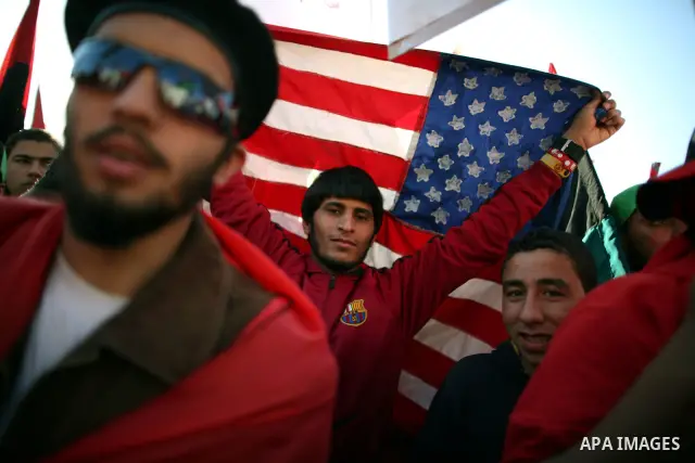 A Libyan youth holds US flag at a market in the eastern rebel stronghold of Benghazi on May 17, 2011 Photo by Wissam Nassar