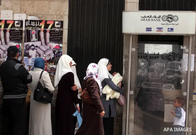 Palestinians receive their salaries for the month of May through ATMs banks in the West Bank city of Ramallah on May 17, 2011, as Palestinian Authority delayed to pay salaries for this month after Israel banned in paymen...