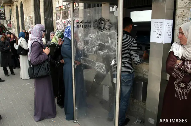 Palestinians receive their salaries for the month of May through ATMs banks in the West Bank city of Ramallah on May 17, 2011, as Palestinian Authority delayed to pay salaries for this month after Israel banned in paymen...