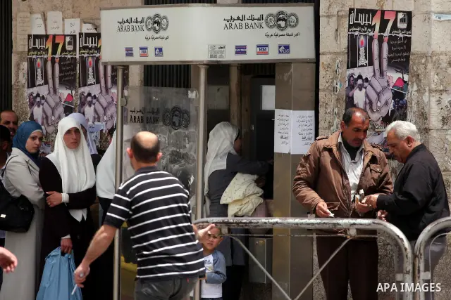 Palestinians receive their salaries for the month of May through ATMs banks in the West Bank city of Ramallah on May 17, 2011, as Palestinian Authority delayed to pay salaries for this month after Israel banned in paymen...